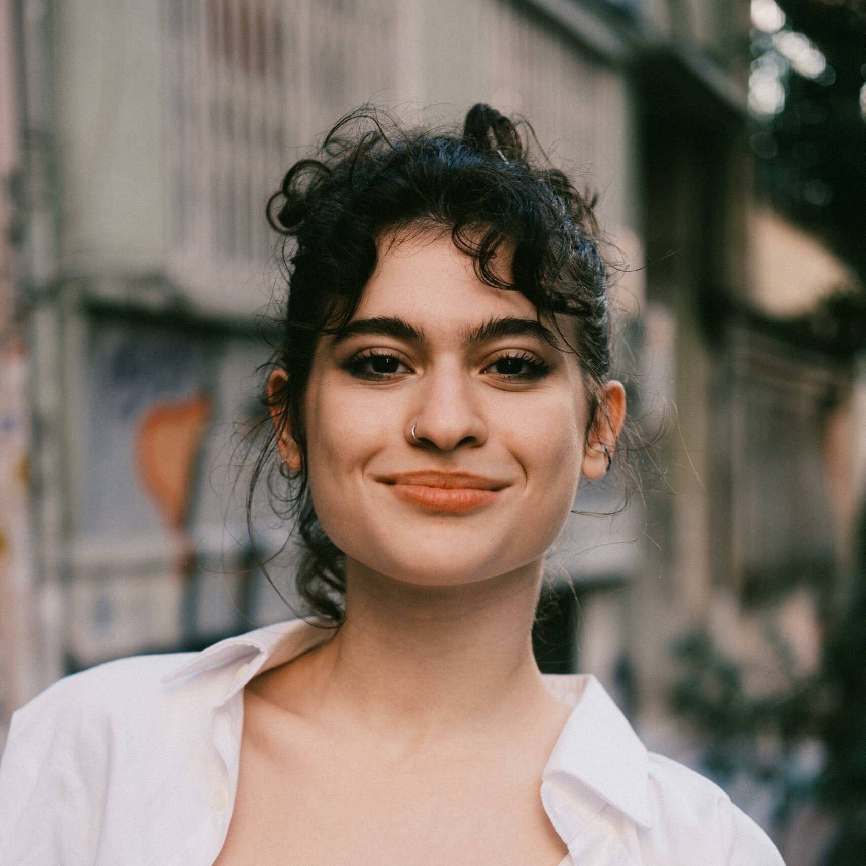 Smiling Woman on Urban Street in Casual Attire